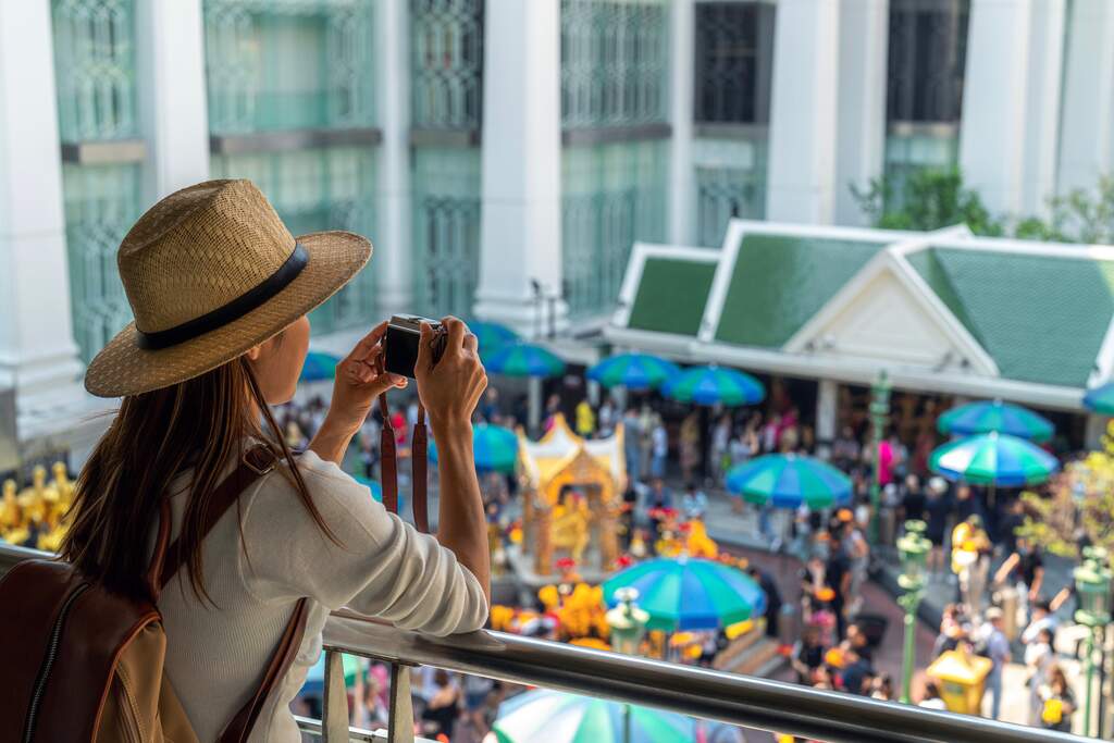 A female tourist visiting Erawan Shrine in Langsuan, Bangkok